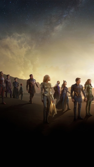 The Eternals standing on a beach under a starry sky