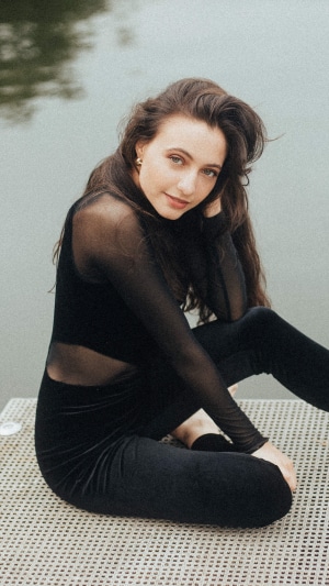 Model in black outfit by water