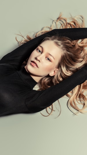 Blonde model lying down wearing black top