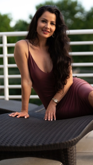 Brunette model in a dress on a lounge chair
