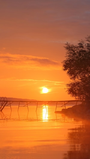 Sunset over a lake with a wooden pier