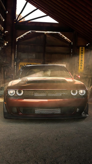 Red Dodge Challenger SRT Hellcat in a garage