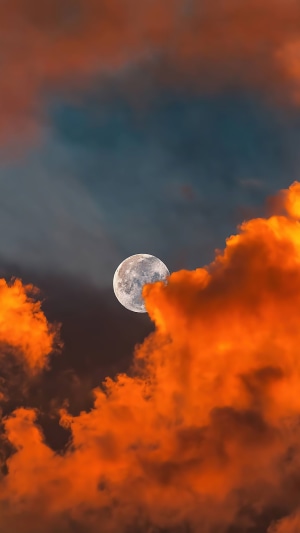 Full moon behind orange and dark clouds 4K