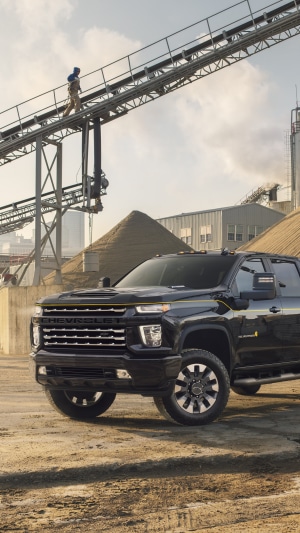 Black Chevrolet Silverado truck at industrial site
