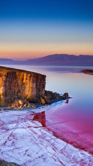 Pink salt lake with cliffs at sunset 4K