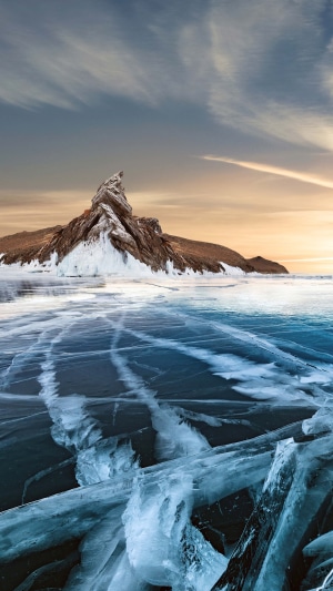 Frozen Lake Baikal with Rocky Island and Sunset Sky