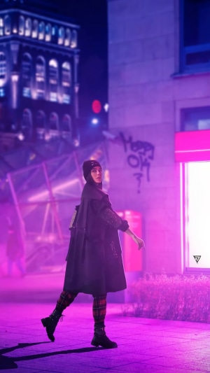 Woman in trench coat walking in neon city at night