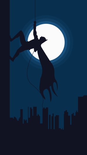 Batman hanging from a rope in front of the moon