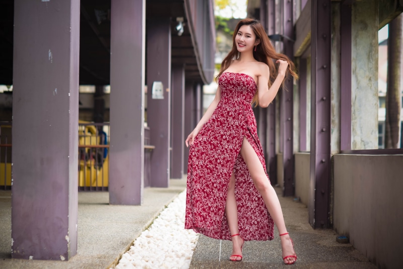 Asian woman in red floral dress posing