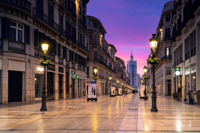 Malaga street at dusk with street lights and buildings