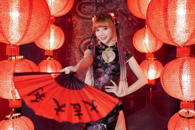 Woman in Cheongsam with Hand Fan and Lanterns