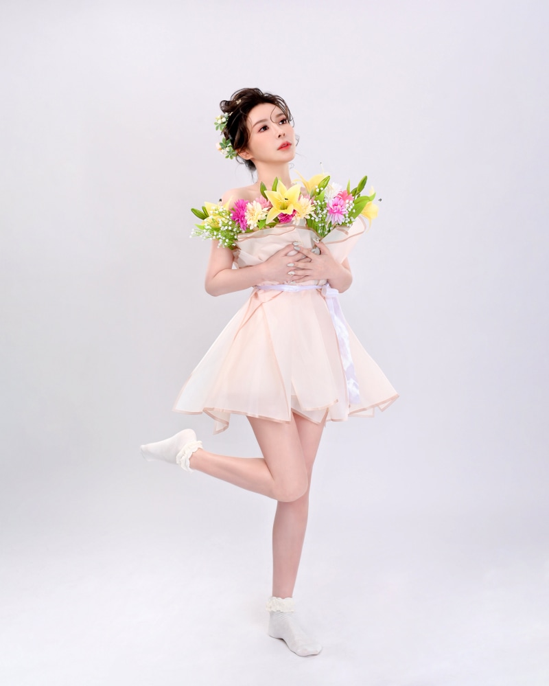 Woman in a light pink dress holding a bouquet