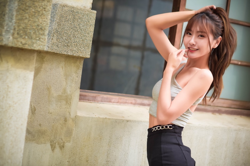 Asian woman with brown hair in a singlet and black skirt