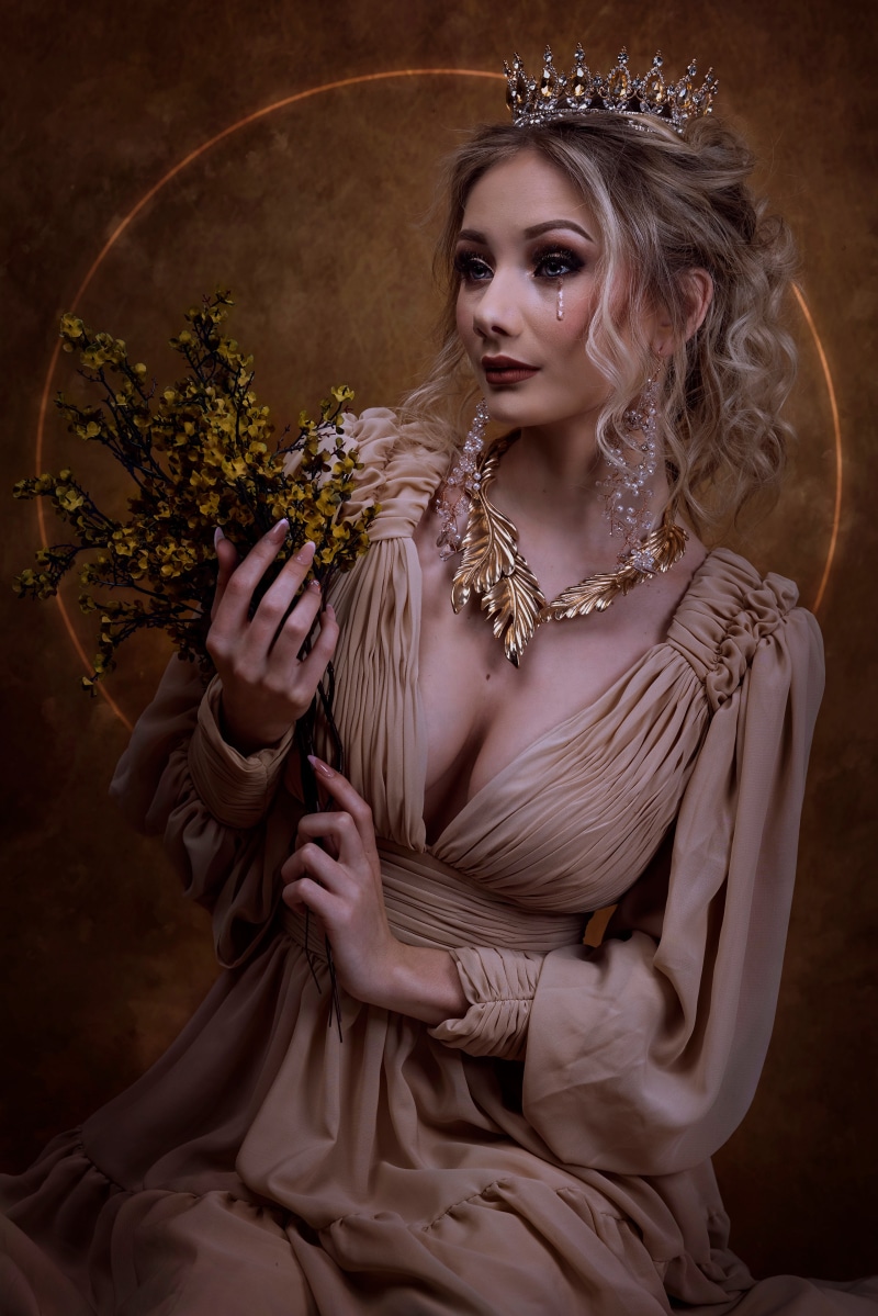 Woman in a crown and dress holding flowers