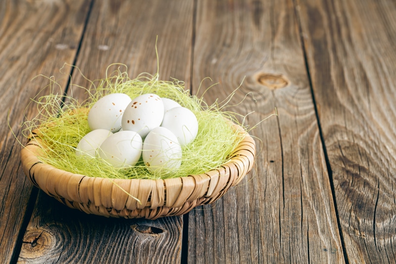 Easter Eggs in a Basket on Wooden Table