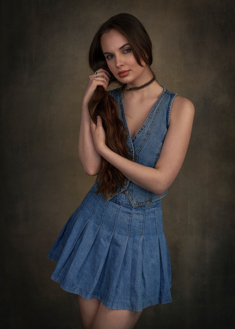 Emilia with brown hair in a denim outfit