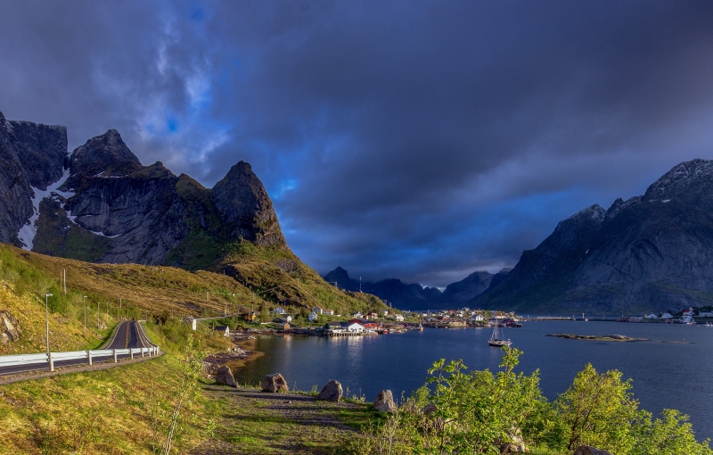 Village nestled between mountains in Lofoten, Norway under stormy clouds