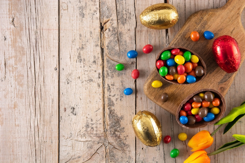 Easter Chocolate Eggs and Candies on Wooden Table