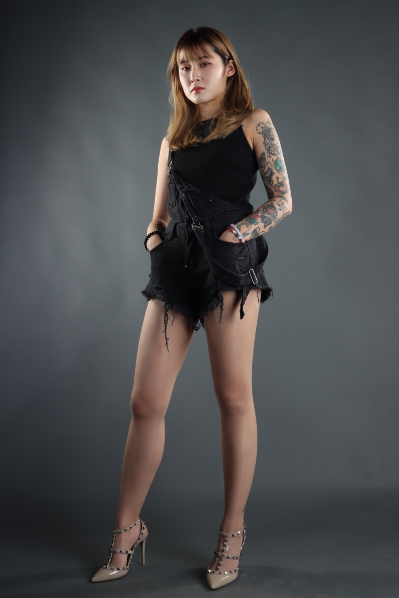 Asian woman in black denim shorts and heels