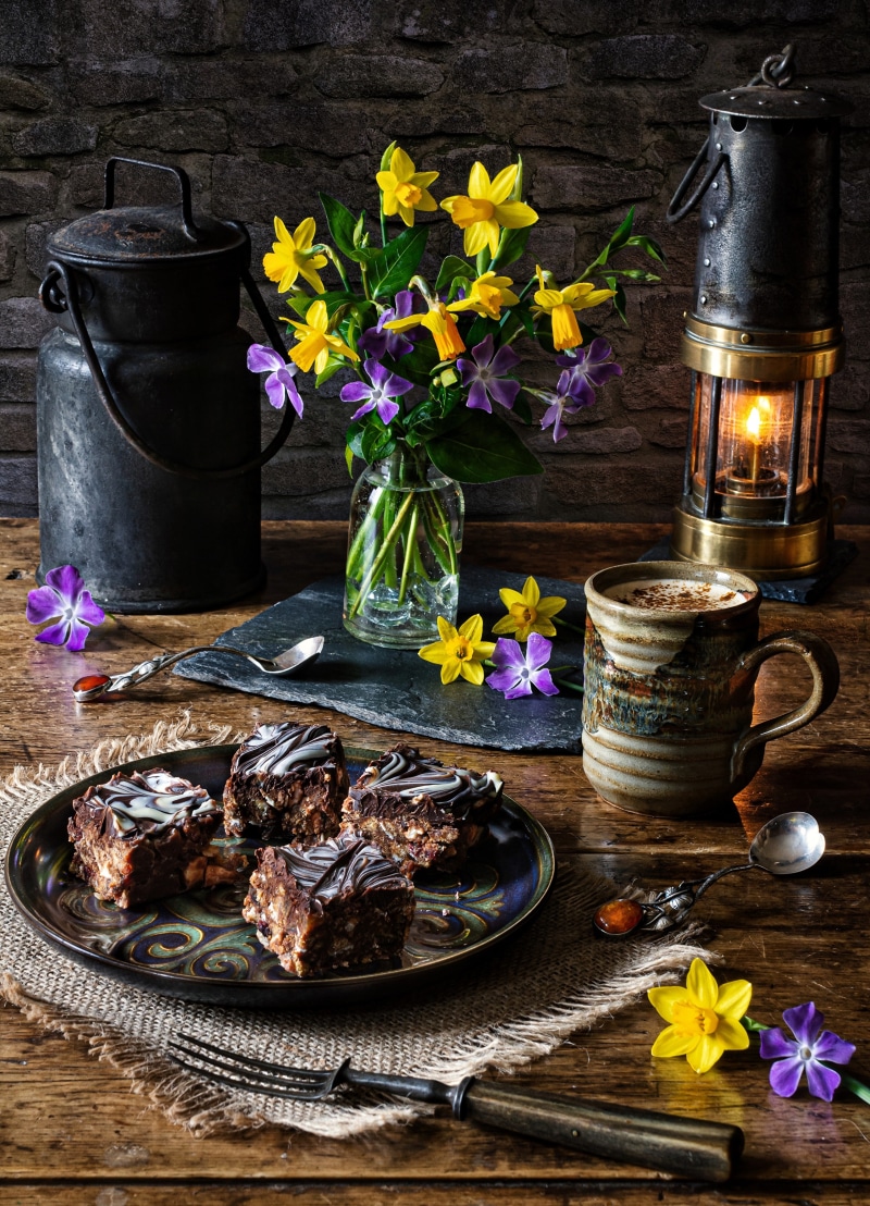 Still-life with cakes, daffodils, and a kerosene lamp
