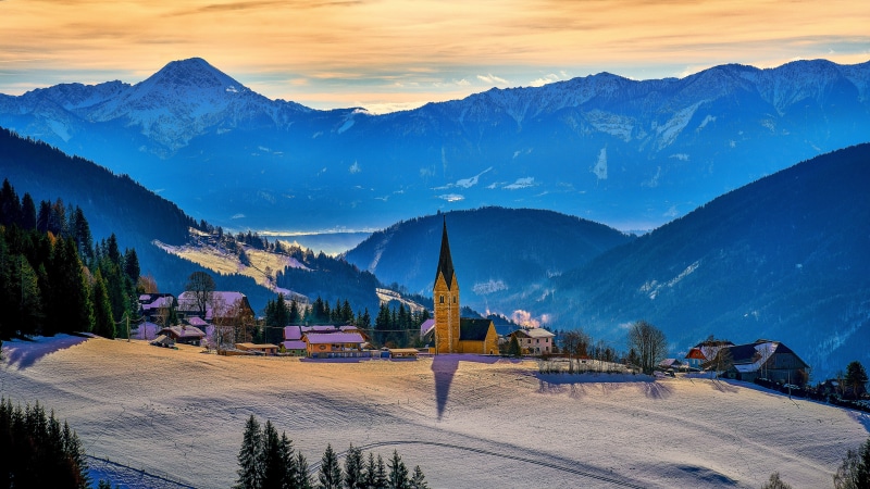 Snowy Austrian Alps village with church and mountains
