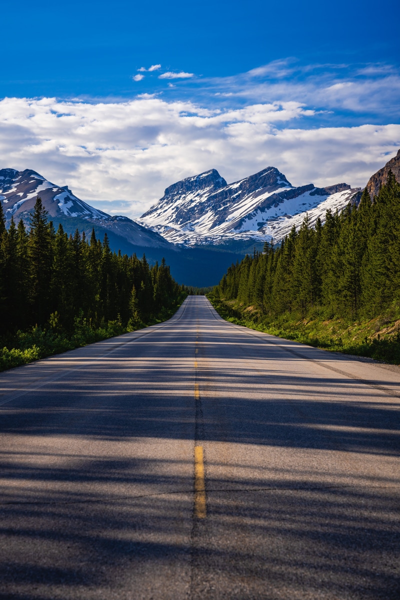 Road through Banff National Park with snow-capped mountains