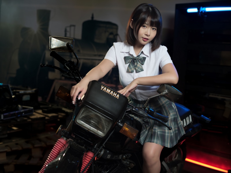 Asian girl in school uniform on a Yamaha motorcycle