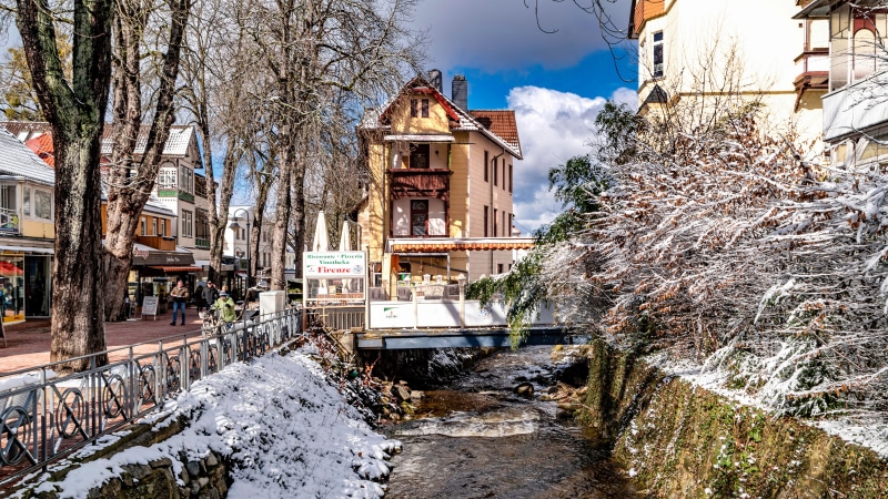 Street with canal and snow in Bad Harzburg, Germany