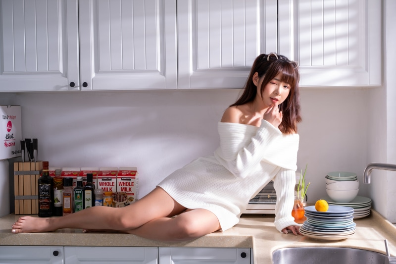 Asian woman in white dress in kitchen