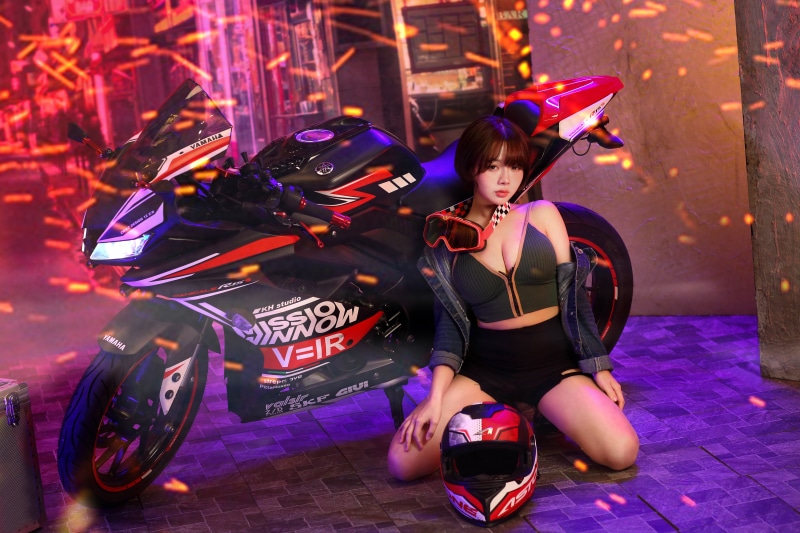 Asian woman posing with Yamaha motorcycle and helmet