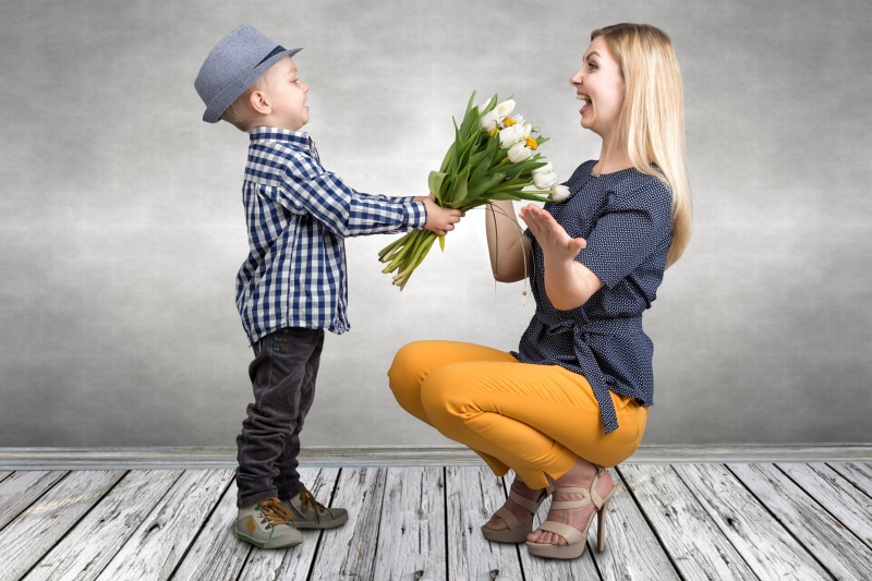 Boy gives tulips to a happy woman