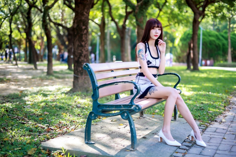 Asian woman sitting on a park bench