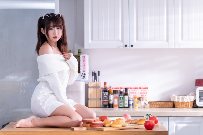 Asian woman in white dress in kitchen