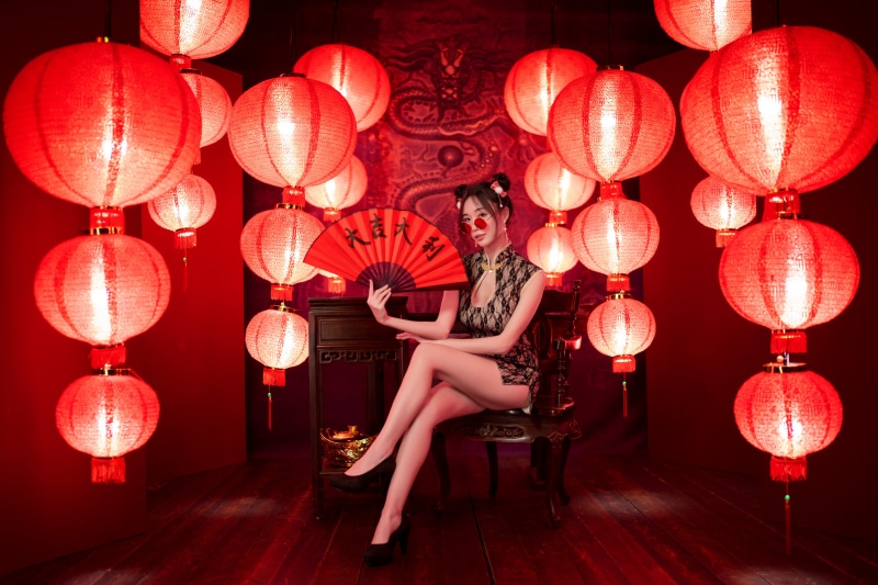Woman in Cheongsam with Hand Fan and Lanterns