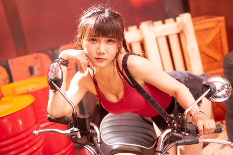 Asian woman posing on a scooter