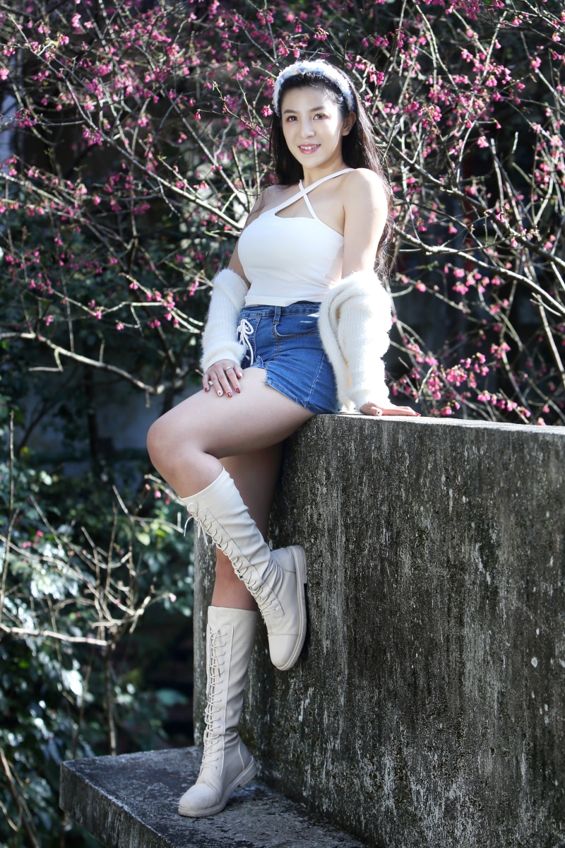 Asian woman wearing white top and denim shorts with boots