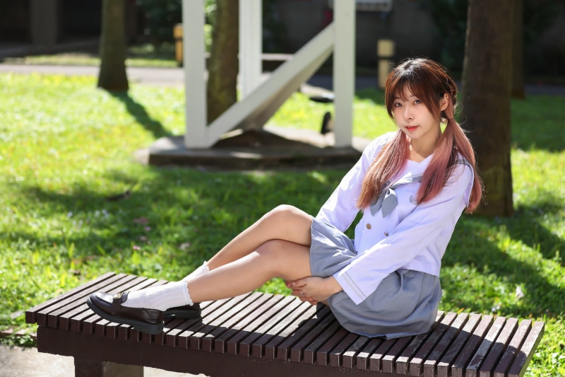 Asian schoolgirl sitting on a bench