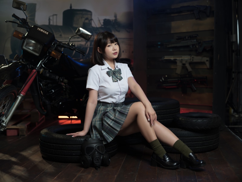 Asian woman in school uniform with motorcycle and guns