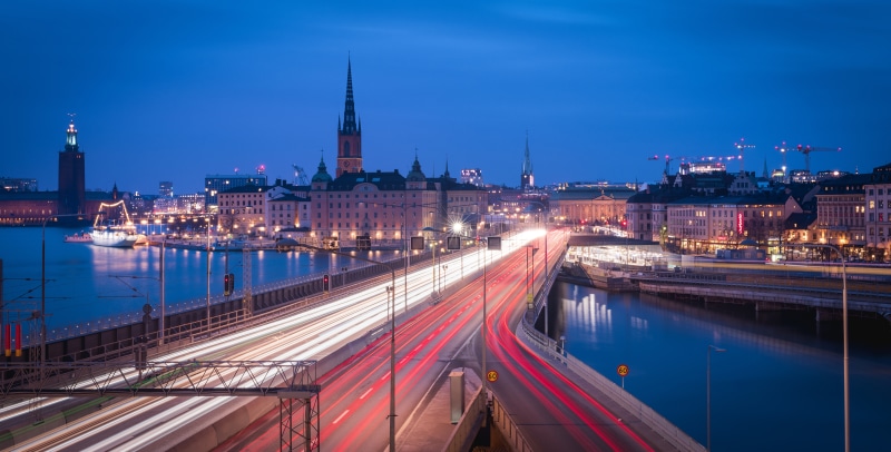 Stockholm skyline with light trails on bridge at dusk