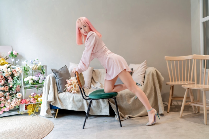 Asian woman with pink hair in a pink dress posing