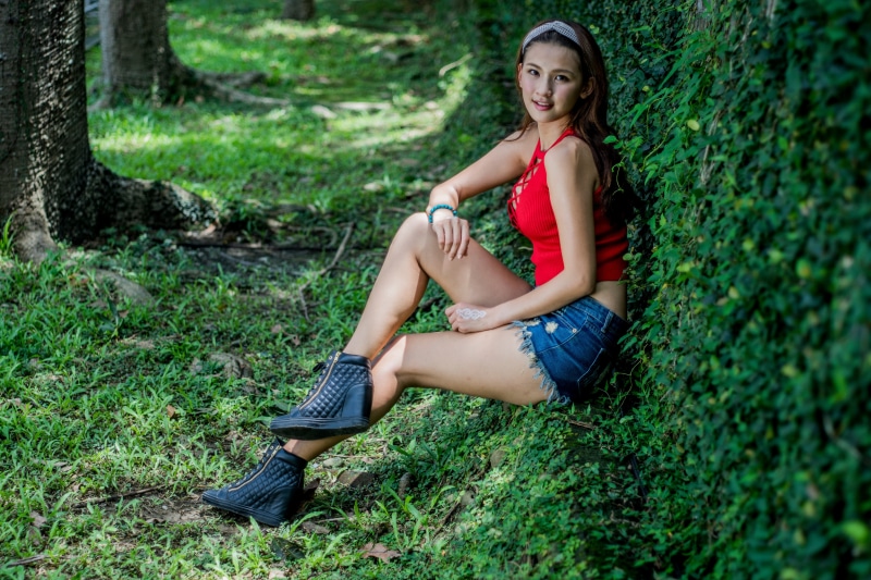 Asian woman sitting in grass