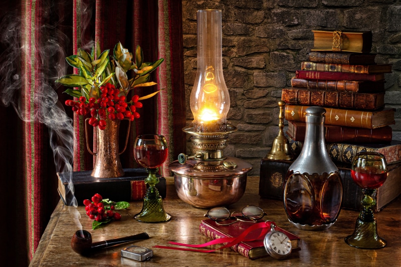 Still-life with kerosene lamp, books, and wine