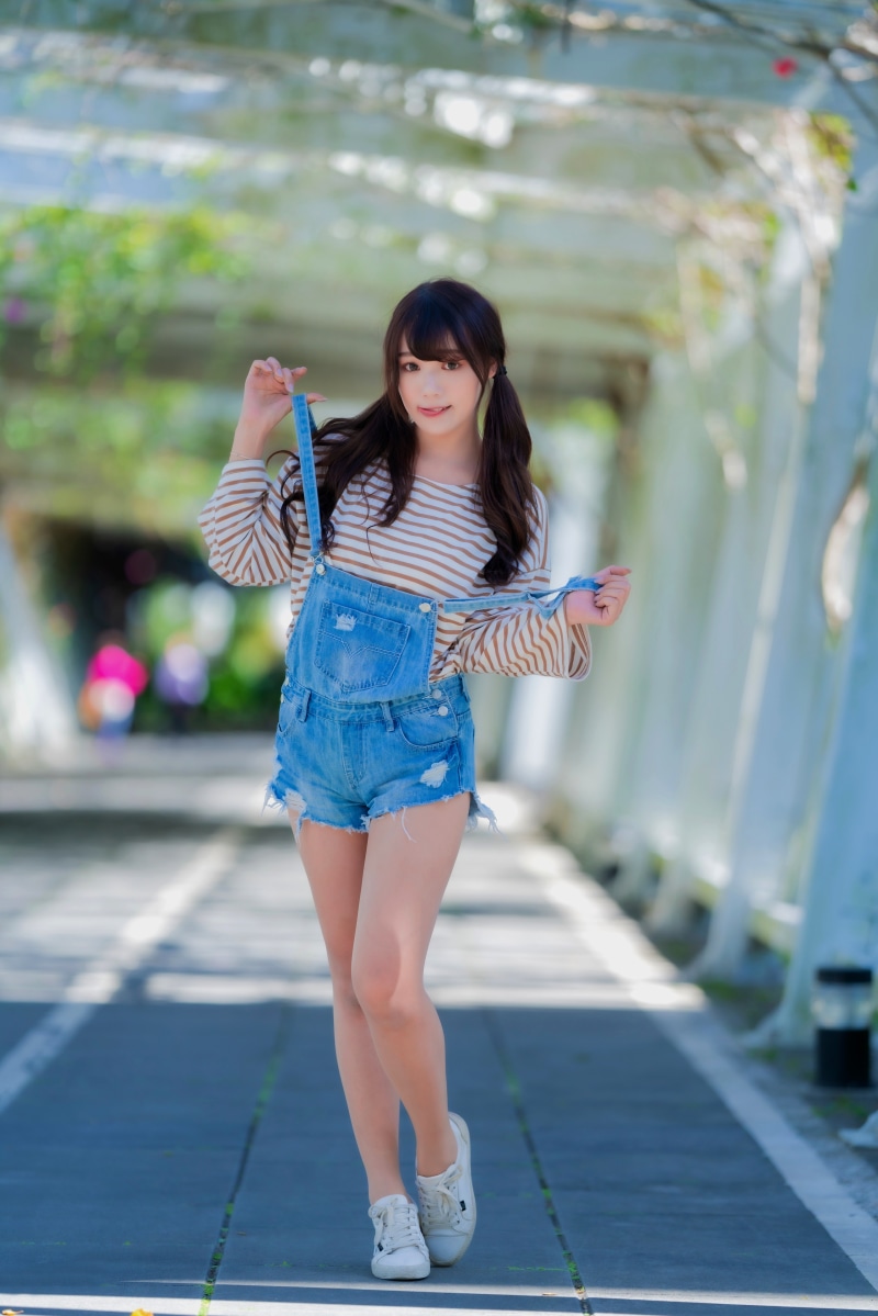 Asian woman in denim overalls and striped shirt