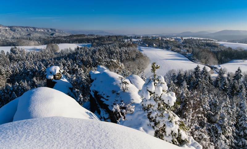 Winter Scenery in Rathen, Germany with Snow-Covered Mountains and Trees
