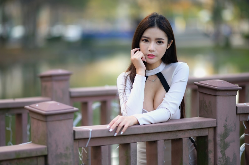 Asian woman in white dress with décolletage