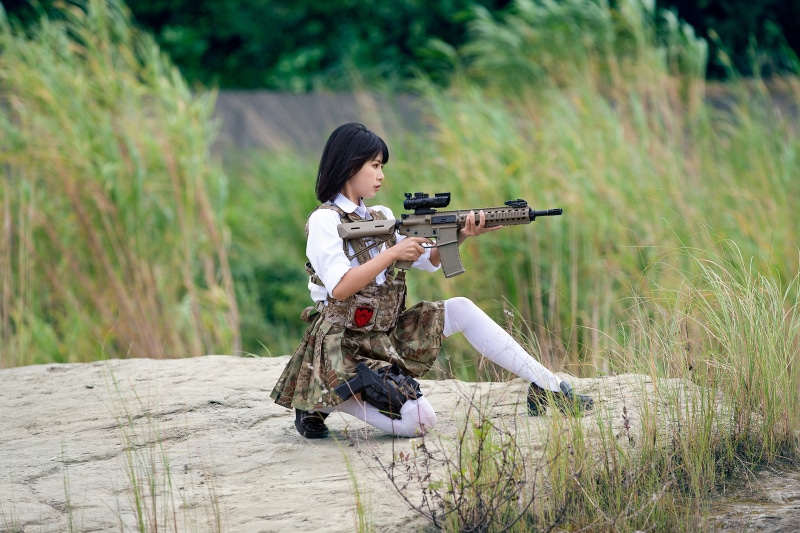 Brunette girl with rifle and pistol