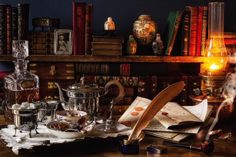 Vintage study with books, tea set, and oil lamp