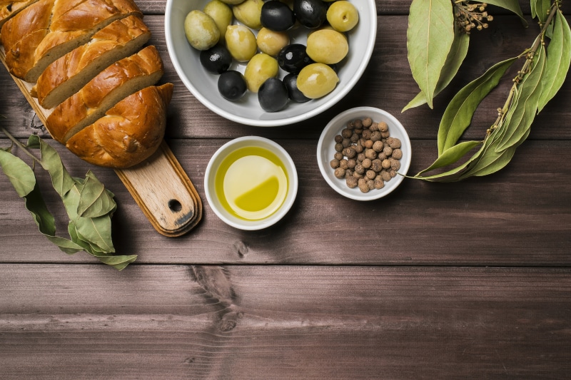Bread, Olives, Oil, and Spices on a Wooden Table