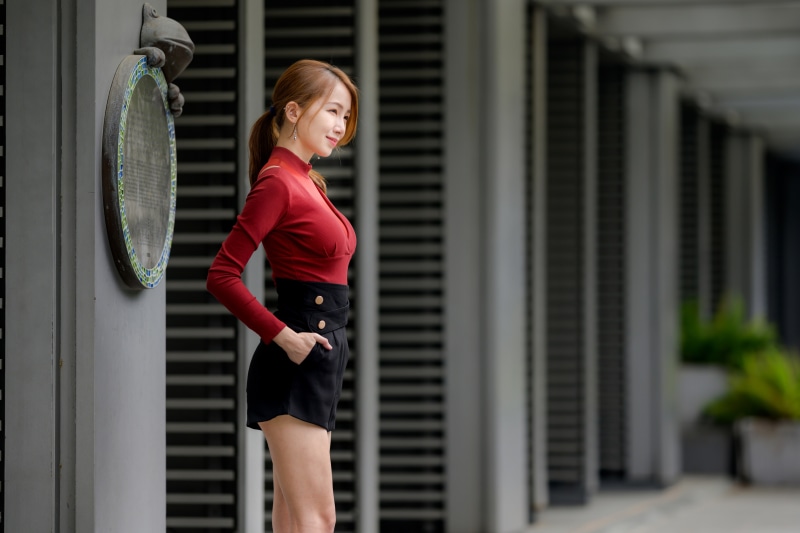 Asian woman in red blouse and black shorts