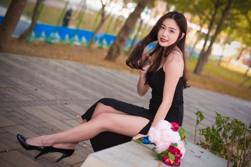 Asian woman in black dress with bouquet